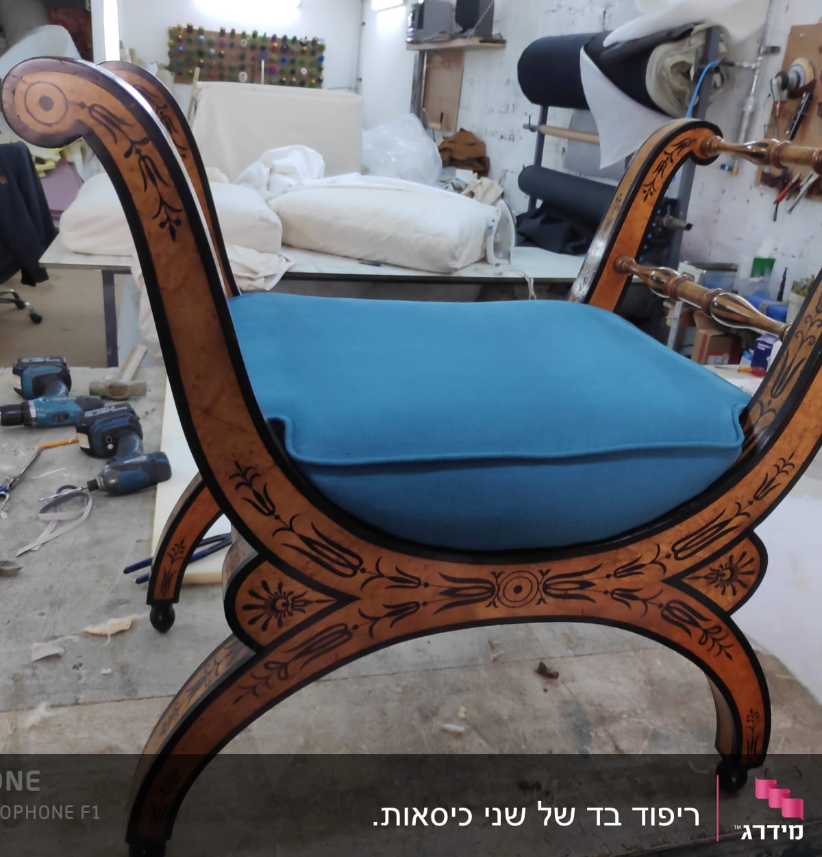 כיסא עם ריפוד כחול וסדנת ריפוד ברקע